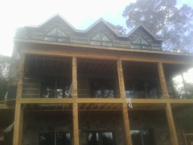 Dormers and porch framing on a large log home under construction — Roof Coating work by our crew in Gauley Bridge