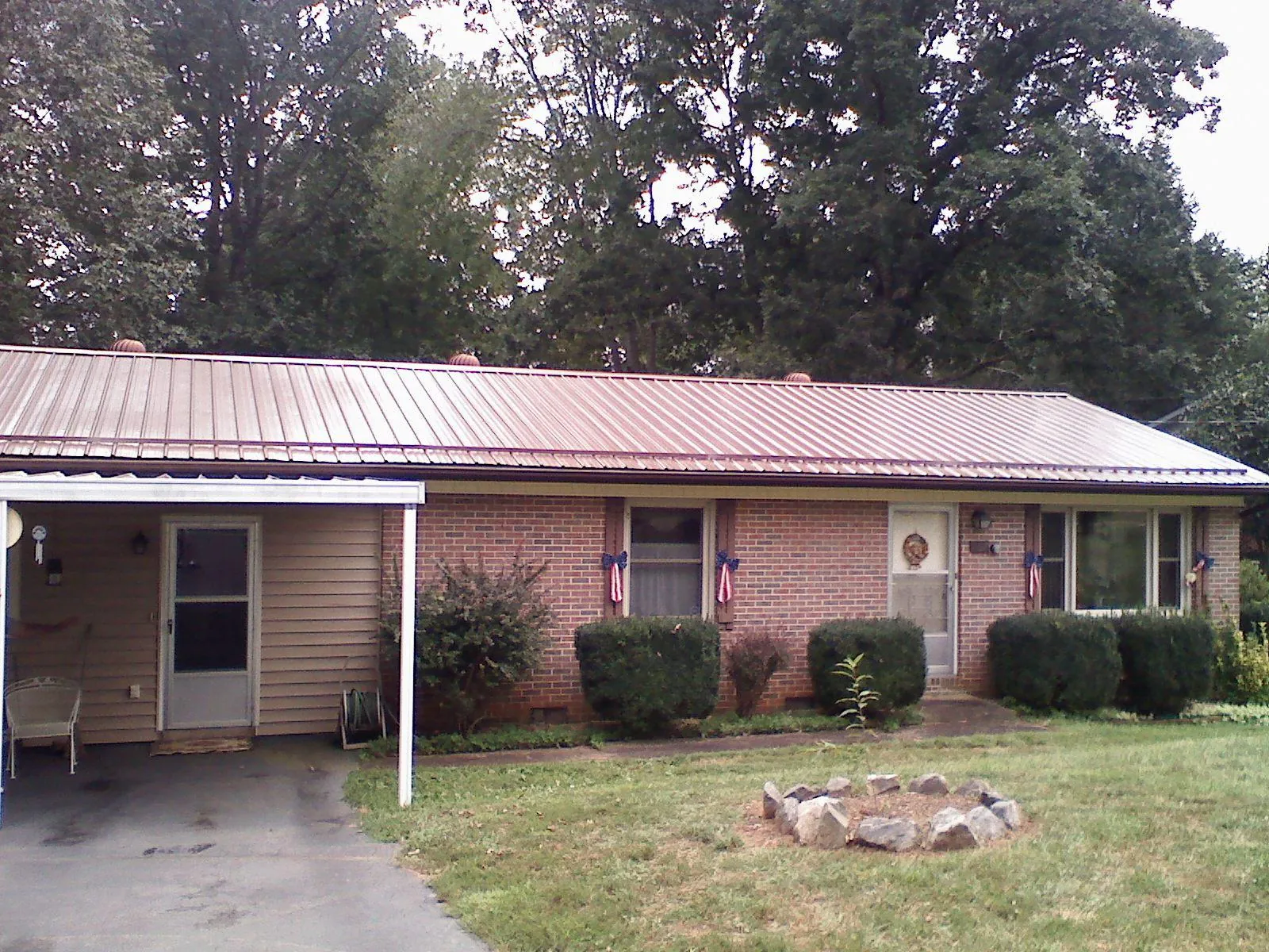 Bronze metal roof and carport on a brick ranch home — Roof Repair work by our crew in Gauley Bridge